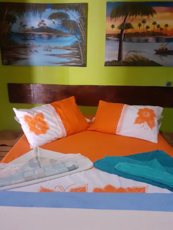 een bed met oranje en witte kussens erop bij Aloha Noronha Hostel in Fernando de Noronha