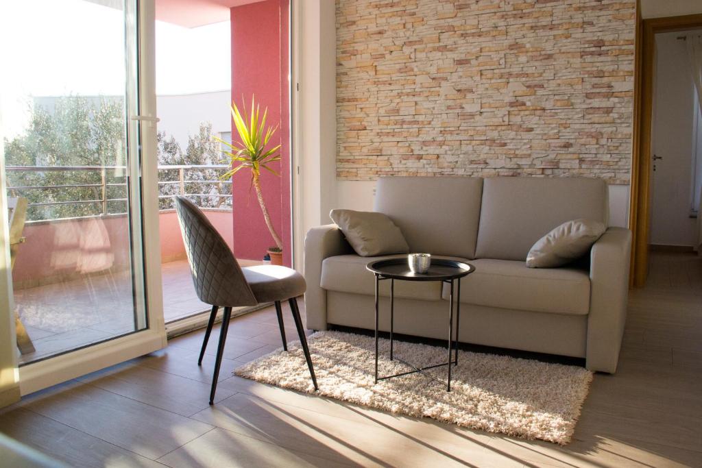 - un salon avec un canapé et une table dans l'établissement Apartments Karla, à Bibinje