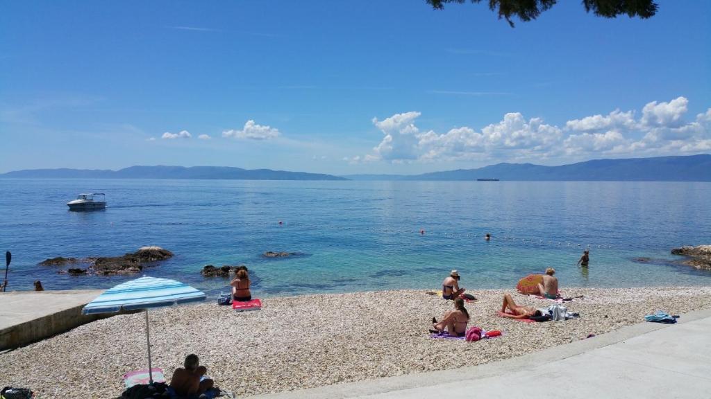 een groep mensen op een strand bij het water bij Volcano Rijeka in Rijeka