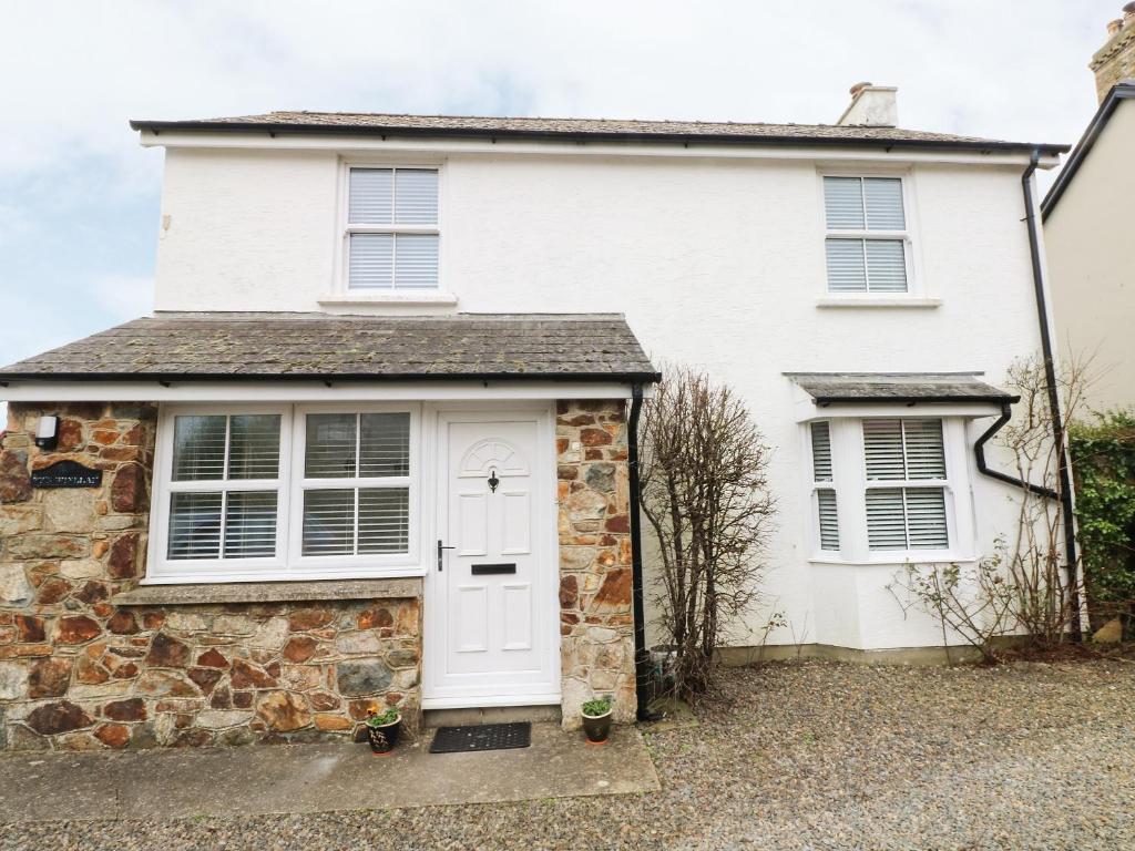 una casa blanca con una puerta blanca en Ty'r Winllan, en Newport