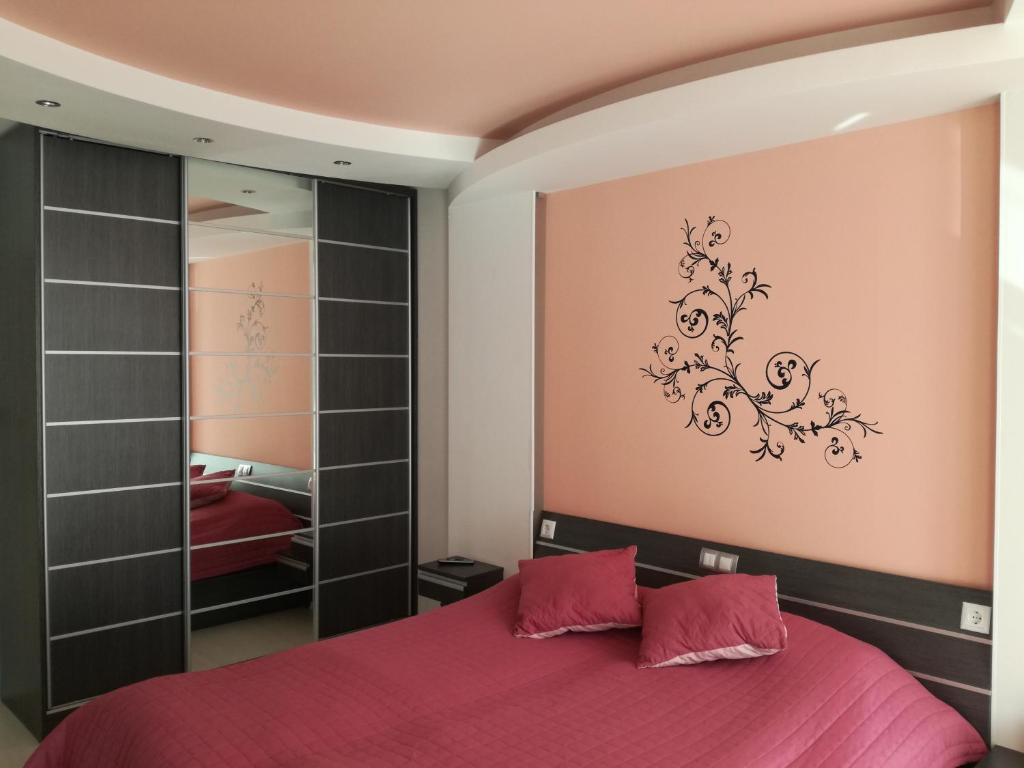 a bedroom with a red bed and a mirror at Apartment 33 in Hotel Iceberg in Borovets