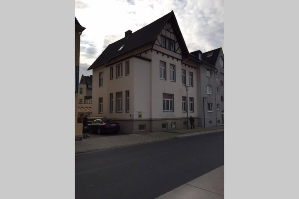 a white building with a black roof on a street at Apartmenthaus Am Bahnhof in Detmold