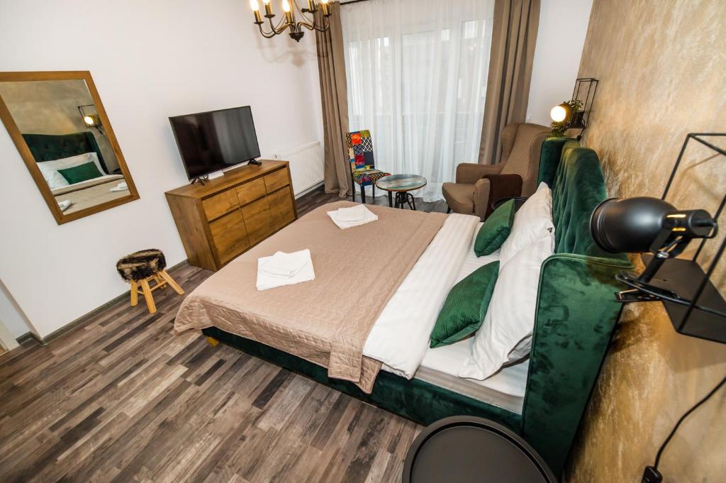 - une chambre avec un lit, un miroir et une télévision dans l'établissement All Homes by Nati, à Braşov