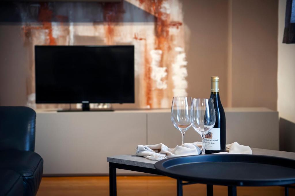 a table with a bottle of wine and two wine glasses at Cerin Apartment in Rovinj