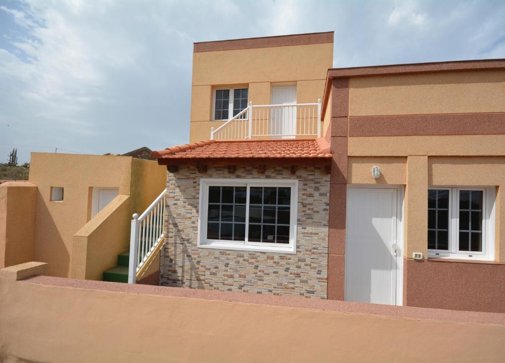 Casa con puerta blanca y balcón en CASA MÉRIDA, en Echedo