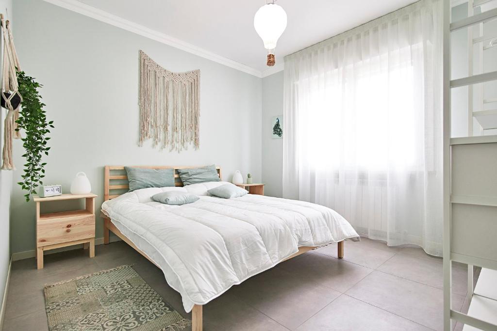 Un dormitorio blanco con una cama grande y una ventana en “Cotton Candy” near Venice, en Spinea