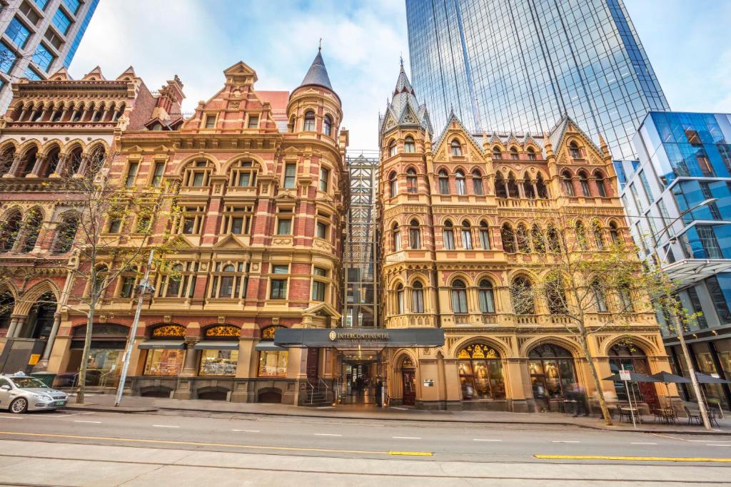 um edifício antigo numa rua da cidade com arranha-céus em InterContinental Melbourne The Rialto, an IHG Hotel em Melbourne