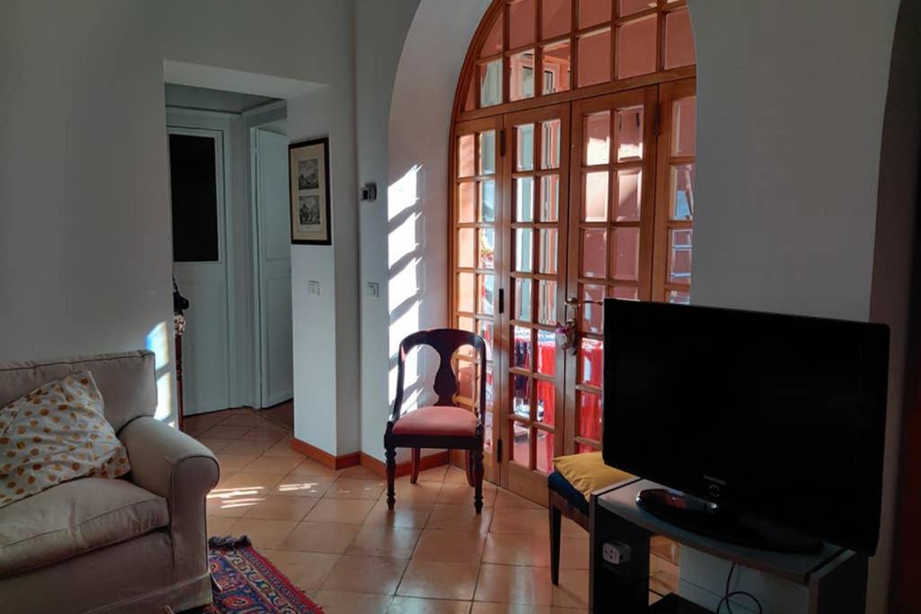 sala de estar con TV, sofá y silla en Lanza Tomasi Apartment - centre, en Roma