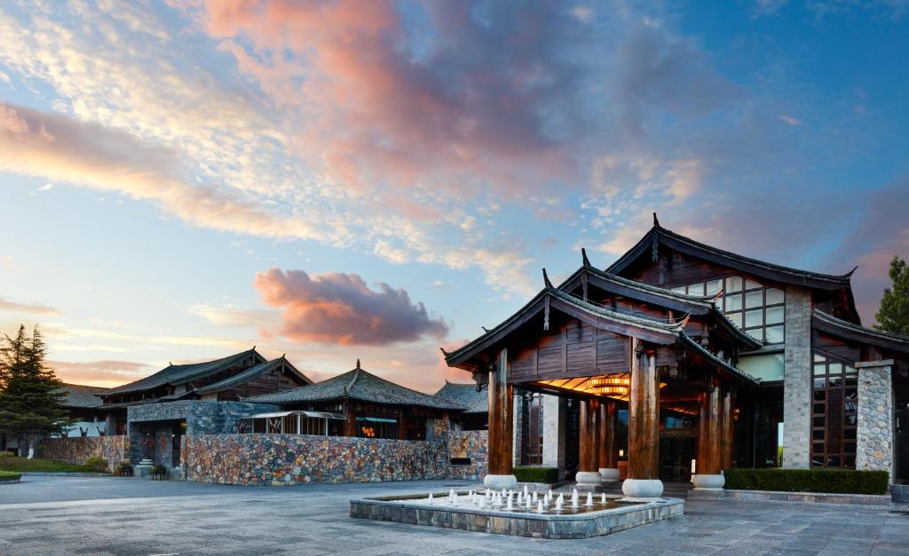 ein Gebäude mit einem Brunnen davor in der Unterkunft InterContinental Lijiang Ancient Town Resort, an IHG Hotel in Lijiang