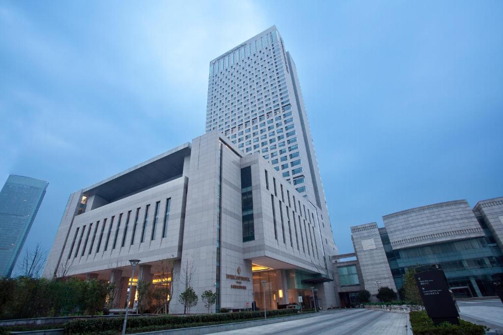 ein hohes Gebäude in einer Stadt mit einer Straße in der Unterkunft InterContinental Wuxi, an IHG Hotel in Wuxi