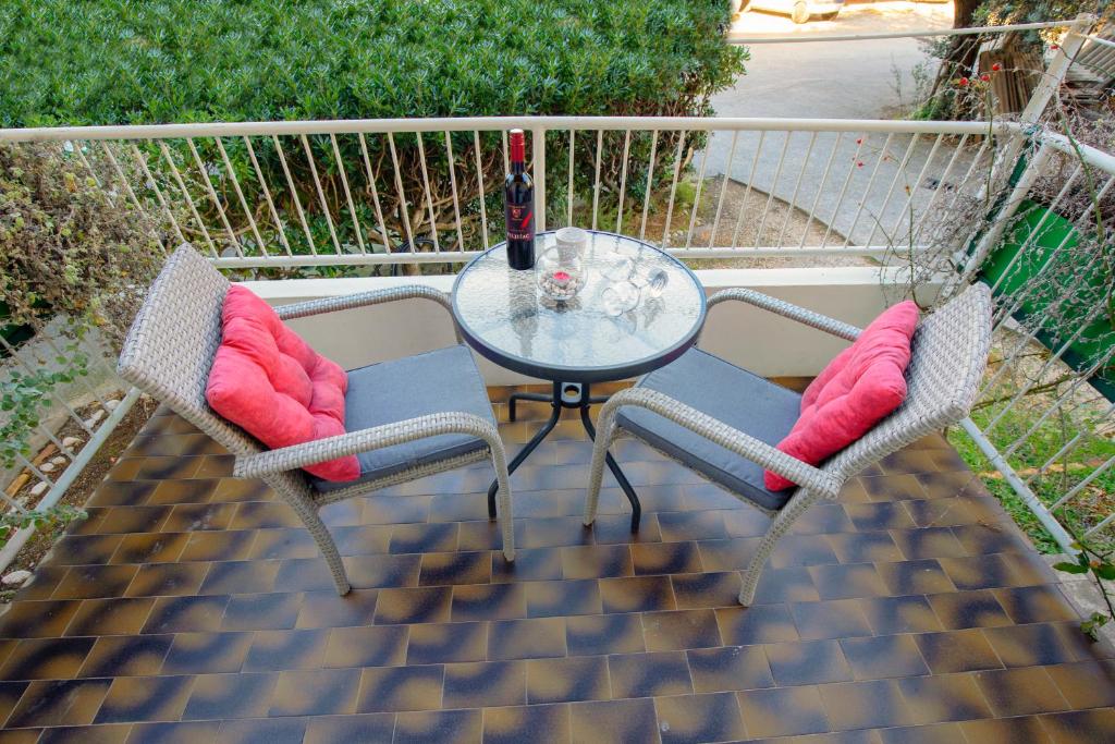 a glass table and two chairs with pink pillows at Ana Guesthouse in Dubrovnik