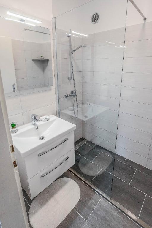 a bathroom with a white sink and a shower at Ana Guesthouse in Dubrovnik