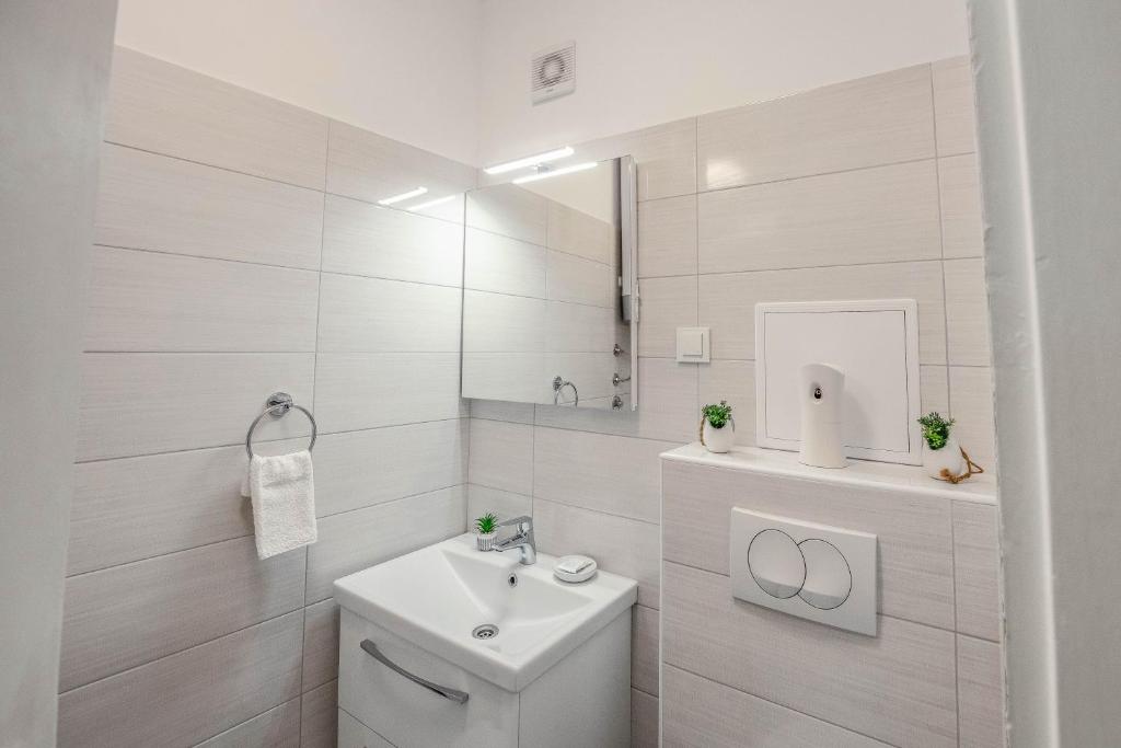 a white bathroom with a toilet and a sink at Ana Guesthouse in Dubrovnik