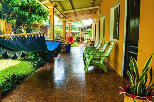 eine Terrasse mit Stühlen und einer Hängematte in einem Gebäude in der Unterkunft Hostal Nathaly in Moyogalpa