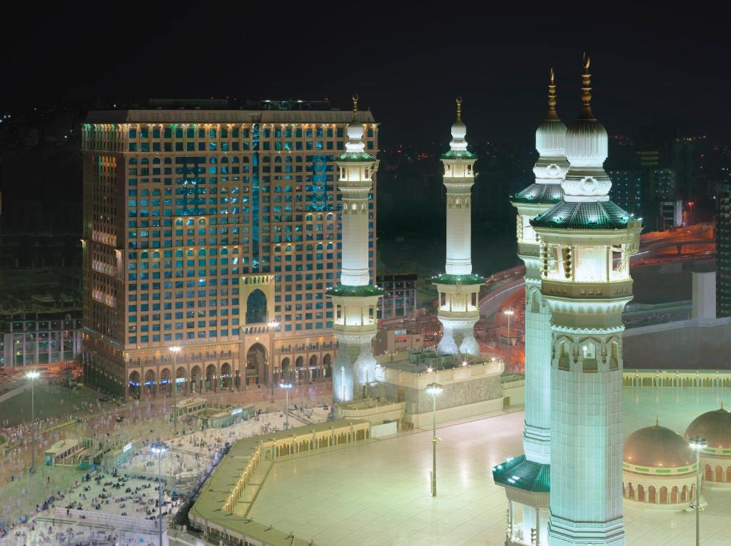 Blick auf eine Stadt in der Nacht mit einem Uhrturm in der Unterkunft Dar Al Tawhid Intercontinental Makkah, an IHG Hotel in Mekka