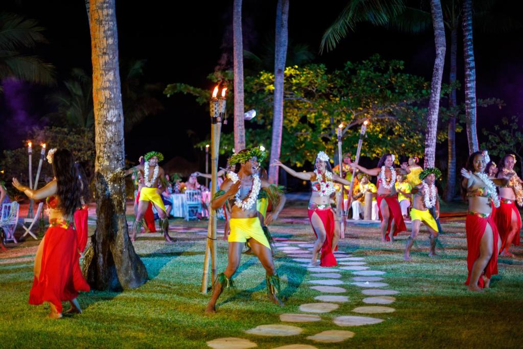 a group of women dancing in the park at night at InterContinental Bora Bora & Thalasso Spa, an IHG Hotel in Bora Bora