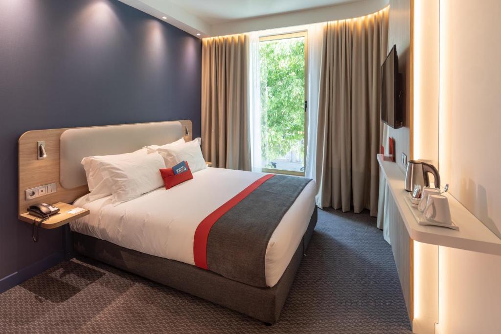 a hotel room with a bed and a window at Holiday Inn Express - Lisbon - Plaza Saldanha by IHG in Lisbon