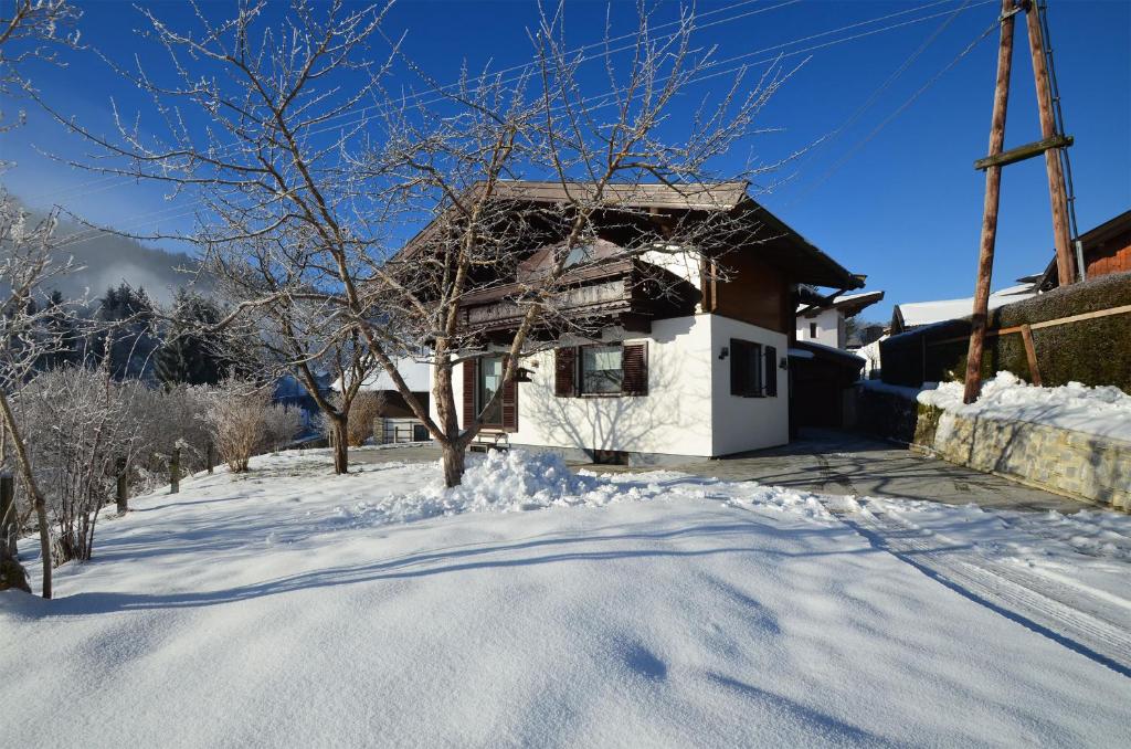 uma casa com neve no chão em frente dela em Finest Ski Chalet Leogang by All in One Apartments em Leogang