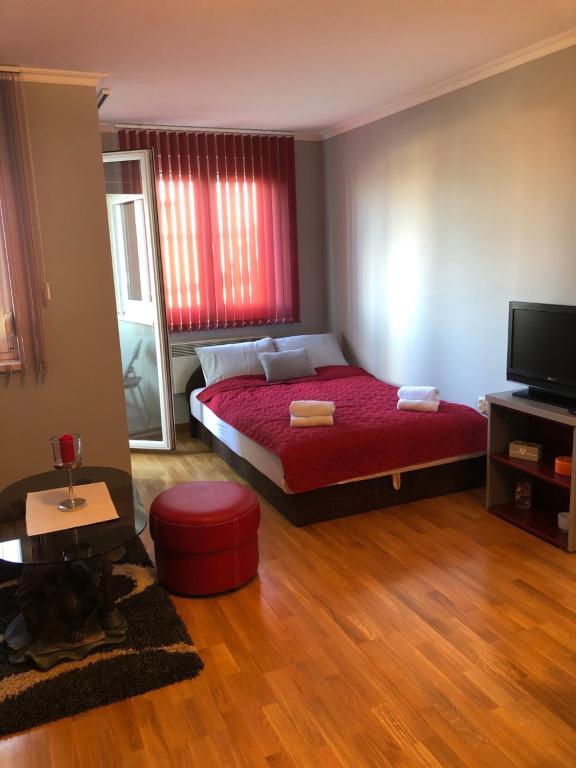 - une chambre avec un lit et une couverture rouge dans l'établissement Studio Mišel 2, à Vrnjačka Banja