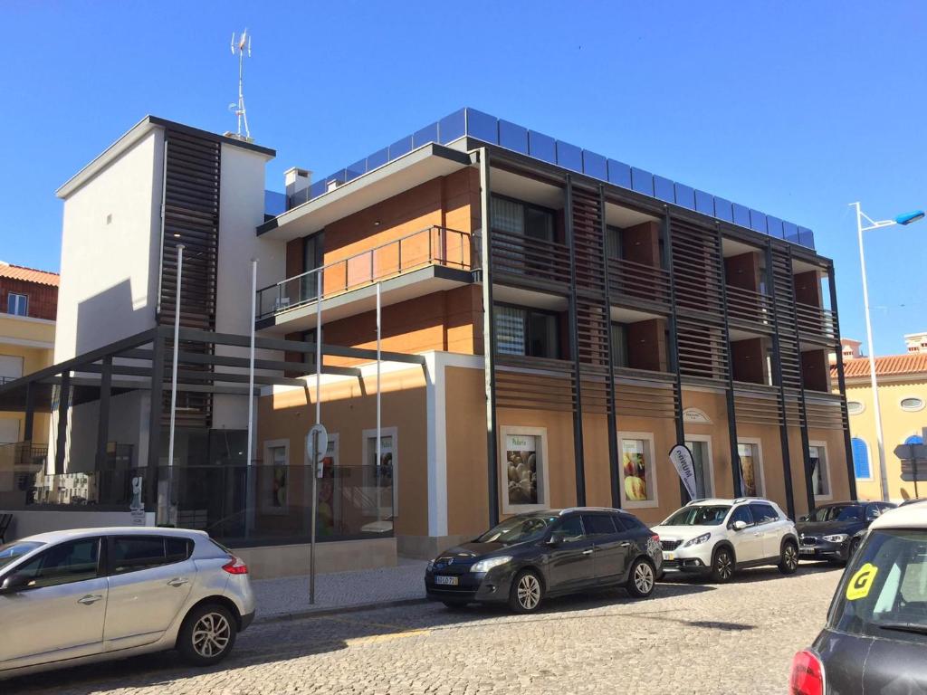 a parking lot with cars parked in front of a building at Duque de Loulé - Apartments - Apartamento D in São Martinho do Porto
