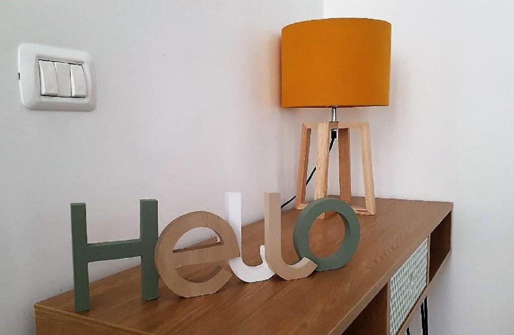 une table avec une lumière et un panneau indiquant leur héritage dans l'établissement Apartment Ostiense Piramide Station, à Rome