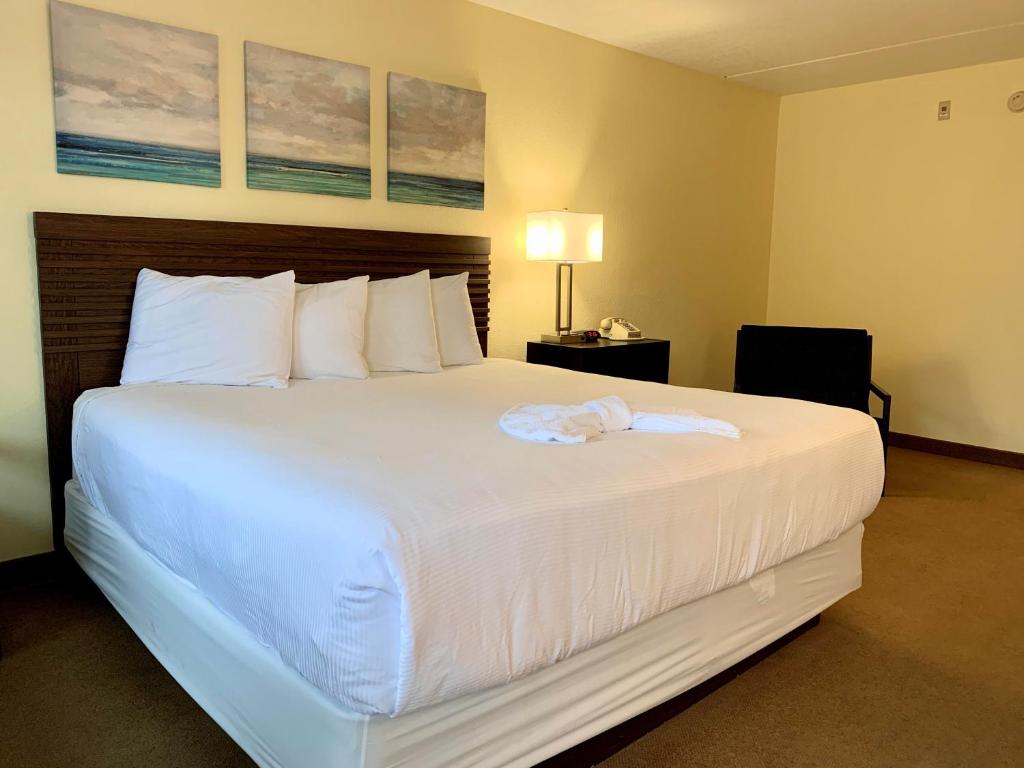 a hotel room with a large bed with white sheets at Seven Gables Inn in Branson