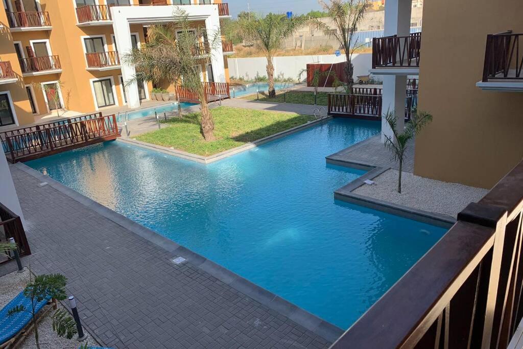a large blue swimming pool in a building at FOREST VIEW LUXURY APARTMENT in 3mins walk to beach pool view wifi in Kololi