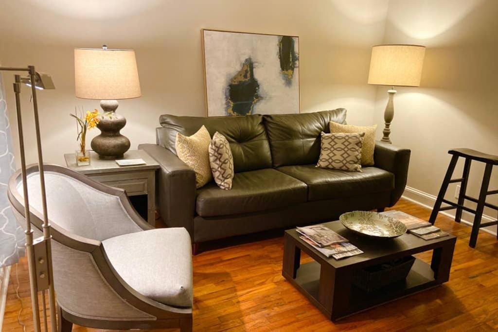 a living room with a couch and a table at Darling Cottage in University Park in Raleigh