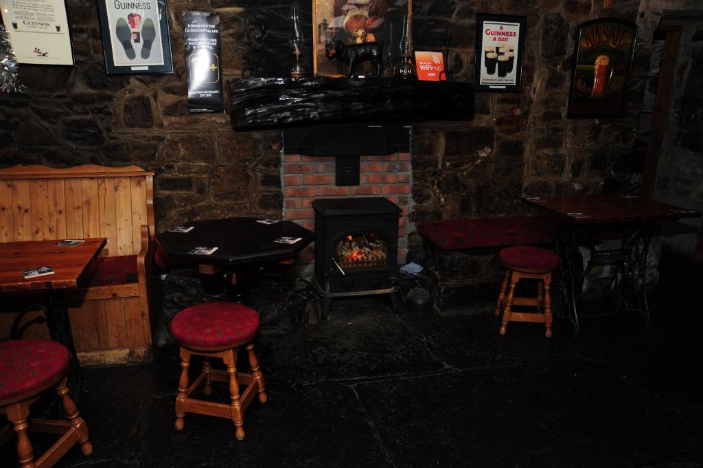 a bar with a fireplace and stools and a stove at The Mill Bar in Athlone