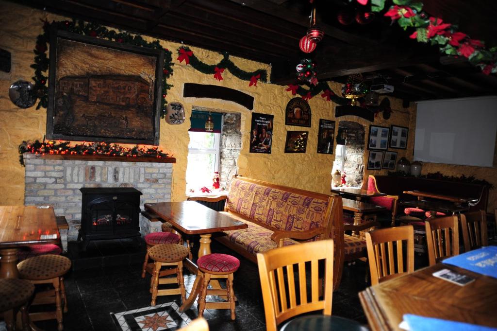 a restaurant with a fireplace and a table and chairs at The Mill Bar in Athlone