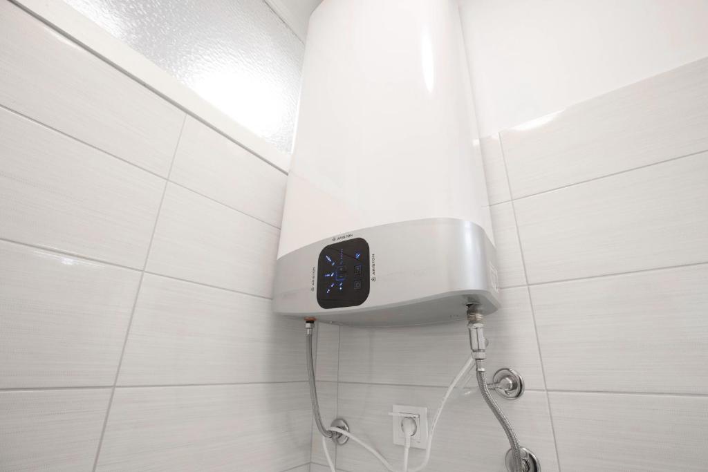 a bathroom with a shower with a clock on the wall at Ana Guesthouse in Dubrovnik