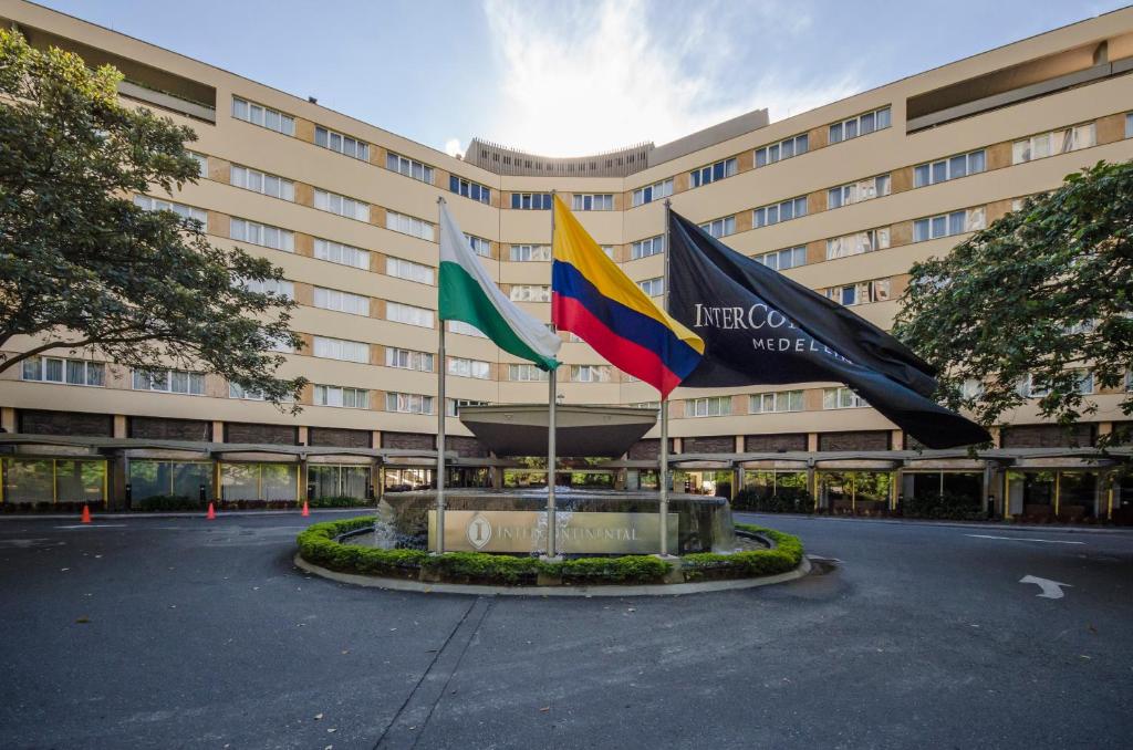 zwei Flaggen vor einem großen Gebäude in der Unterkunft Hotel Intercontinental Medellín, an IHG Hotel in Medellín