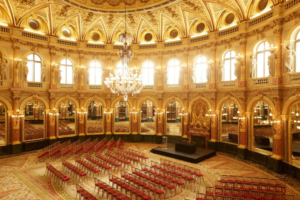 a large room with red chairs and a chandelier at InterContinental Paris Le Grand by IHG in Paris