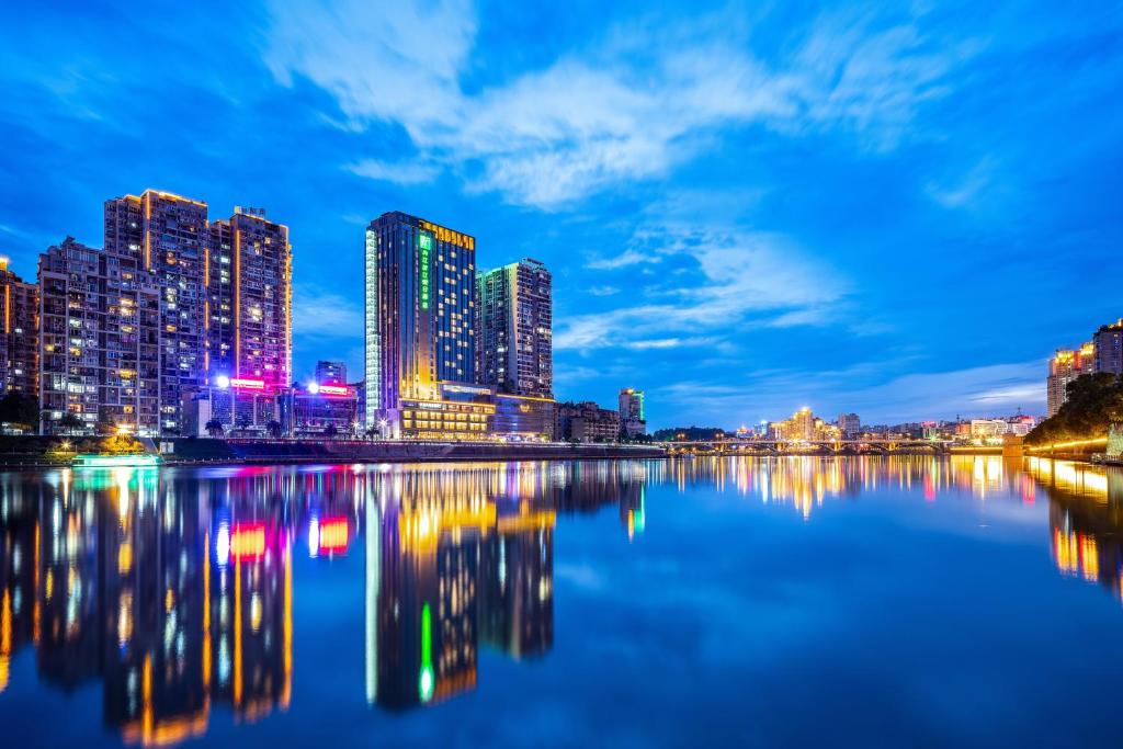 a view of a city skyline at night at Holiday Inn Neijiang Riverside by IHG in Neijiang