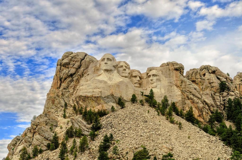 a mountain with statues of faces on it at Holiday Inn Express & Suites - Rapid City - Rushmore South by IHG in Rapid City
