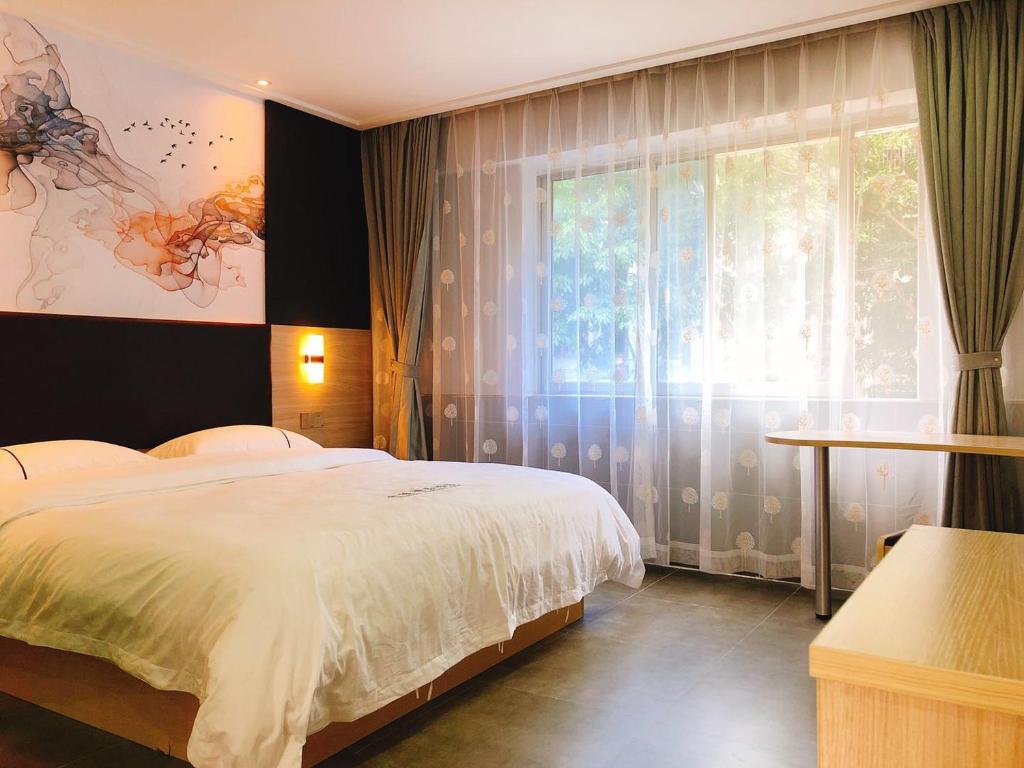 a bedroom with a bed and a large window at  Shenzhen Hualian Boutique Hotel in Shenzhen