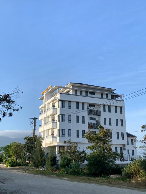 un edificio blanco al lado de una calle en Summering Hotel, en Doc Let