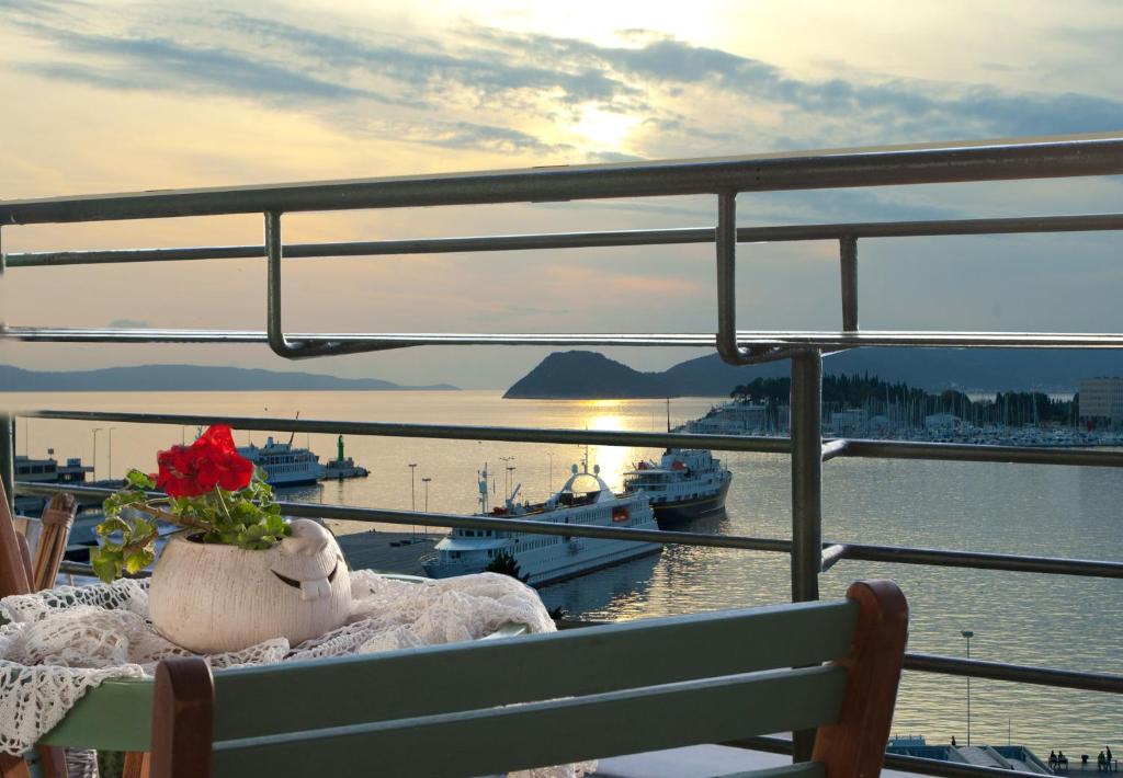 a vase with a red flower sitting on a bench at Stunning View Apartment in Split