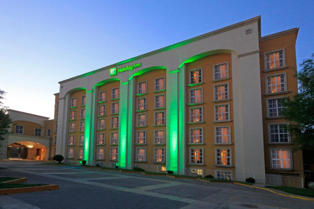 ein Hotel mit grüner Beleuchtung an der Seite in der Unterkunft Holiday Inn Monclova, an IHG Hotel in Monclova