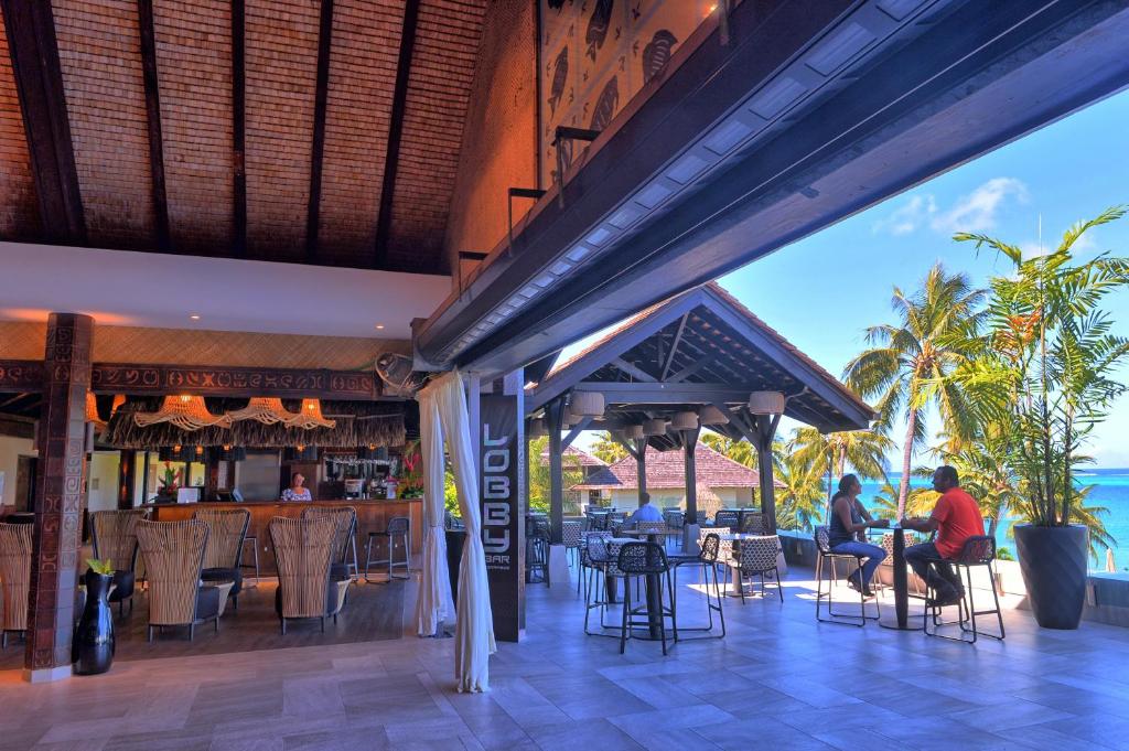 un ristorante sulla spiaggia con persone sedute ai tavoli di InterContinental Tahiti Resort & Spa, an IHG Hotel a Faaa