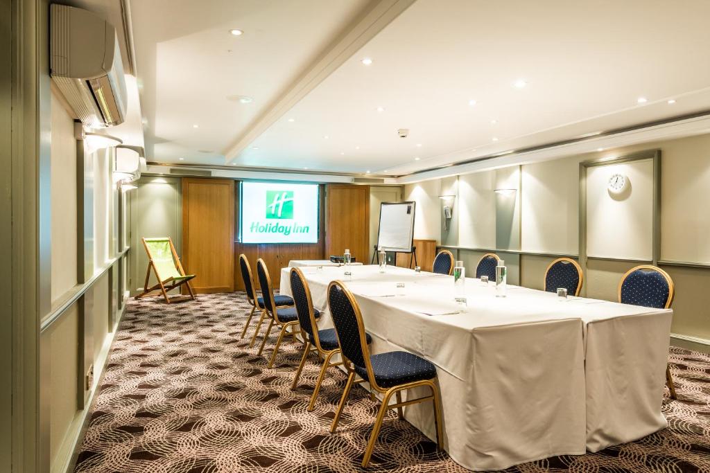 a conference room with a long table and chairs at Holiday Inn Brighton Seafront by IHG in Brighton & Hove