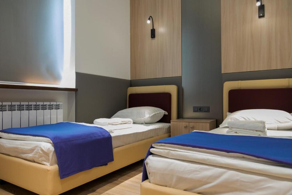 2 Betten in einem blau-weißen Zimmer in der Unterkunft Hotel IRIS in Taschkent