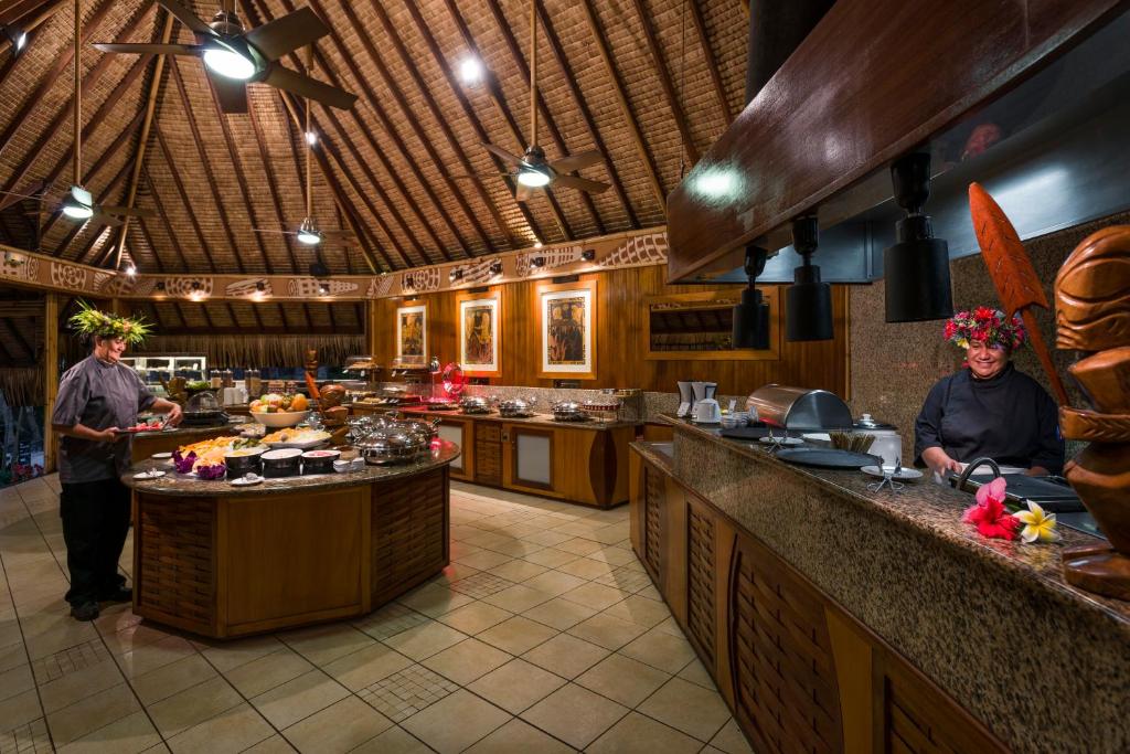 a kitchen with two people standing at the counter at InterContinental Bora Bora Le Moana Resort, an IHG Hotel in Bora Bora