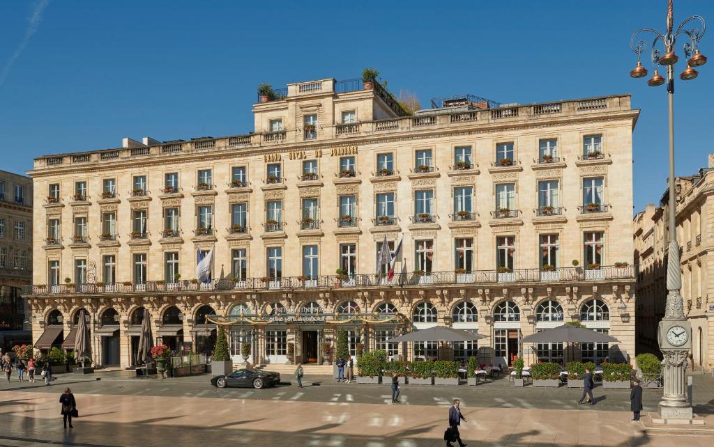 um grande edifício com pessoas andando na frente dele em InterContinental Bordeaux Le Grand Hotel, an IHG Hotel em Bordeaux