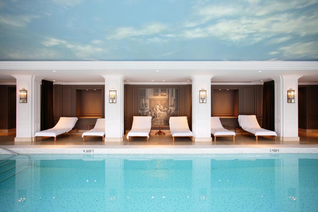 a hotel with a swimming pool and chairs at InterContinental Amstel Amsterdam by IHG in Amsterdam