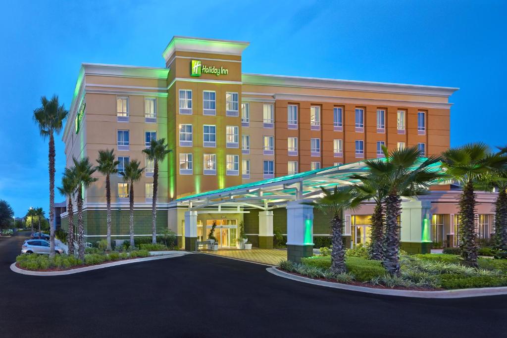 un hôtel avec des palmiers devant lui dans l'établissement Holiday Inn Jacksonville E 295 Baymeadows, an IHG Hotel, à Jacksonville
