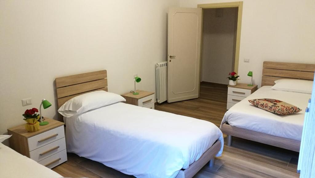 sypialnia z 2 łóżkami z białą pościelą i drewnianą podłogą w obiekcie EApartmentsfoligno w mieście Foligno