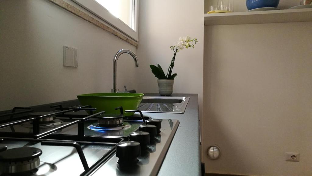 kuchnia ze zlewem i zieloną miską na kuchence w obiekcie EApartmentsfoligno w mieście Foligno