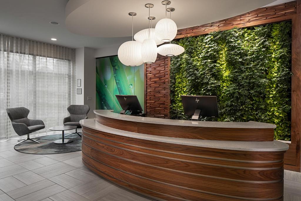 un vestíbulo con una recepción con una pared verde en EVEN Hotel Alpharetta - Avalon Area by IHG, en Alpharetta