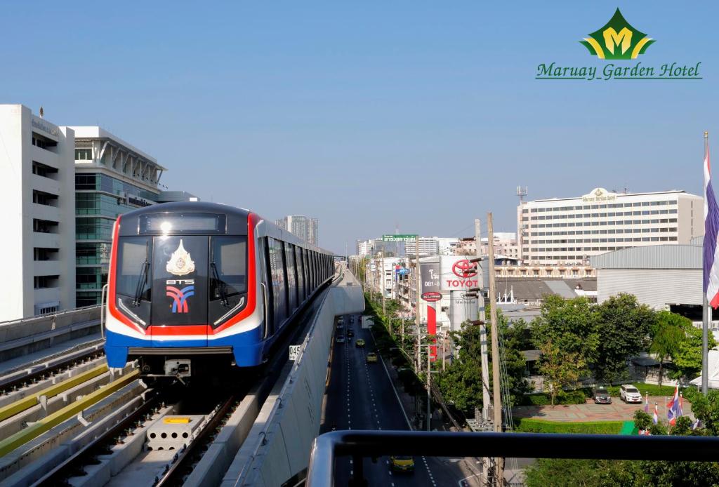 a train on a track in a city at The Maruay Garden Hotel in Bangkok